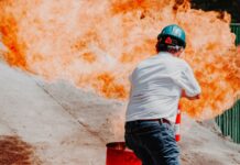화재에 취약한 전통시장, 내달부터 난연 등급 이상 자재 써야 man in white shirt and blue denim jeans wearing black helmet standing on gray concrete road