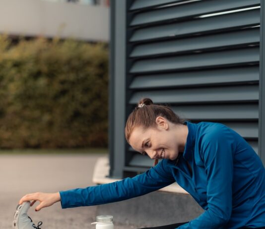 규칙적인 운동의 중요성 a woman sitting on the ground with her foot on a cup