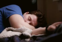 “아무리 자도 개운하지 않아요”…수면 부족이 아니라 ‘수면 질’ 문제입니다 woman in blue shirt lying on bed