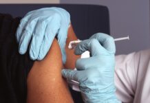 독감 예방접종 본격화… 고위험군 중심 무료 지원 확대 person in white gloves with blue textile on lap