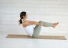 바쁜 일상 속, 필라테스로 건강 챙기는 새로운 트렌드 Woman in boat pose on yoga mat