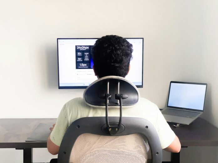 a man sitting in front of a computer monitor