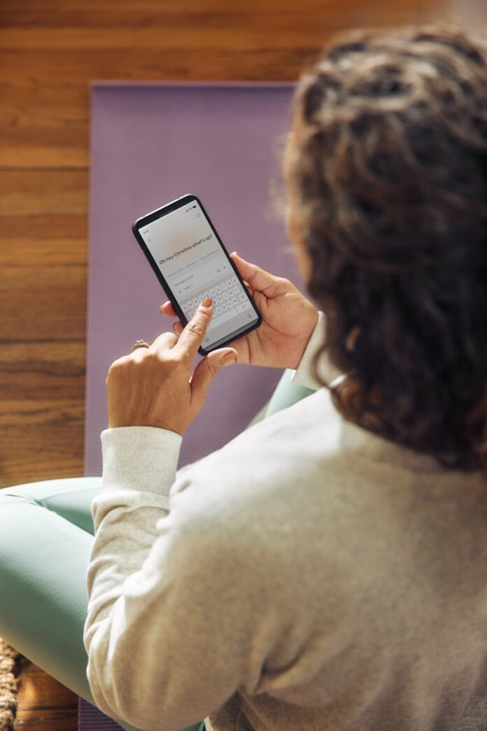 Photo by Microsoft Copilot Woman using a smartphone on a yoga mat.